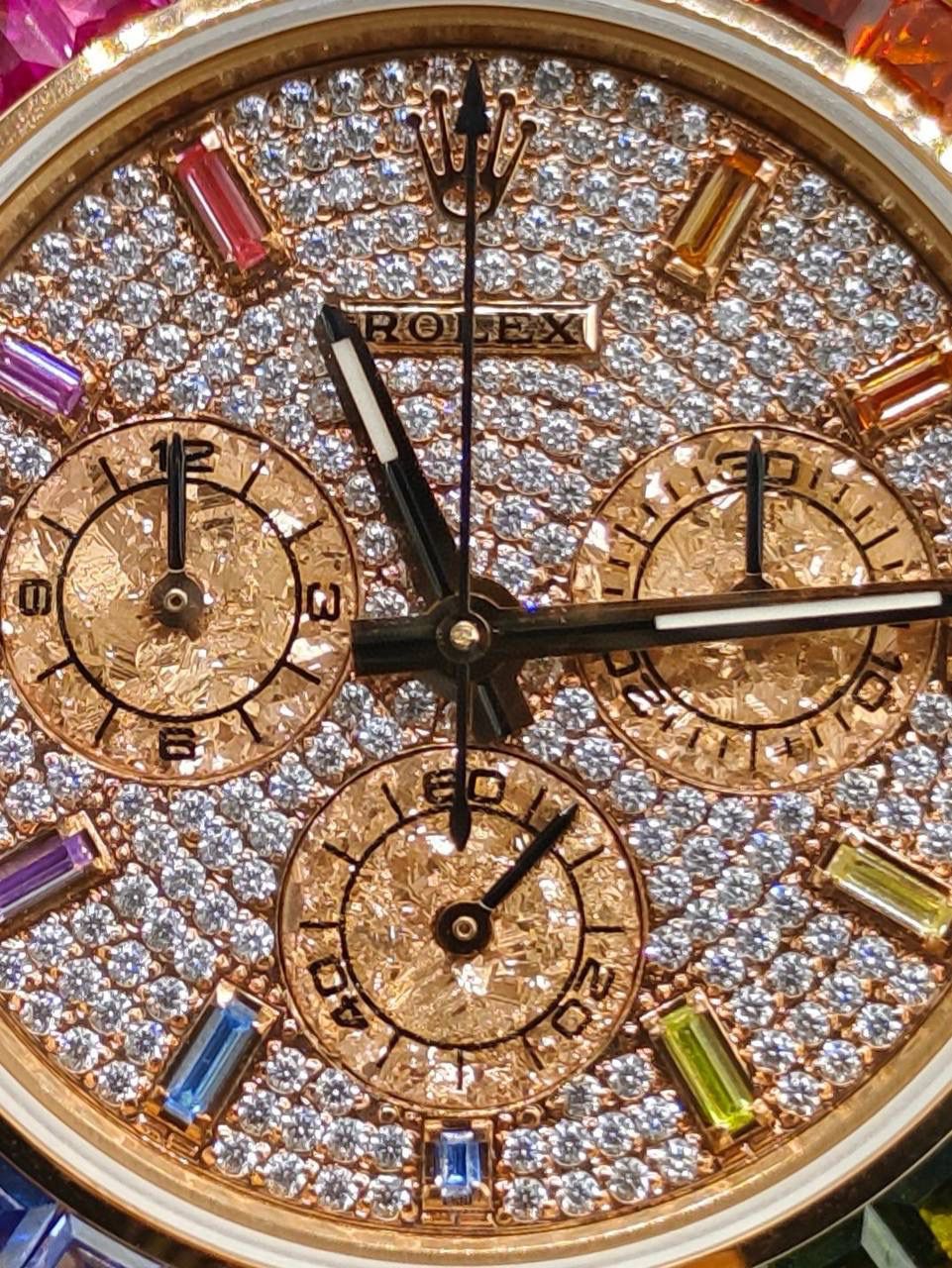 劳家 ROLEX 迪通拿系列 🎮OM6 飞越彩虹之巅---劳力士彩虹迪通拿 铂金眼 铂金小眼Cal.7750机械计时， “二代彩虹迪通拿”表壳、表带采用316L精钢材质打磨，每个壳套全程CNC处理所有细节，再经过人工流程润饰，打磨和检测做工精细，圈口角度与宝石大小数量颜色跟专柜彩虹渐变效果一致，玻璃使用蓝宝石透彻效果镜面，机芯采用7750全自动计时机械机芯，🎮 表带分别全人工镶钻精钢实心表带OR进口氟橡胶表带，配备防止意外打开的蚝式保险扣，佩戴舒适，操作也十分简便！ 这款腕表最大的特点莫过于表圈的七彩宝石和字面的十二个彩钻刻度，彩色渐变效果一一对应，这些宝石闪耀着红橙黄绿青蓝紫等斑斓的色彩，恰似添上曼妙多姿的变化色彩，劳力士精心挑选了玲珑精巧的宝石，并组合镶嵌在了一起，为腕表赋予了奇异的光彩。🎮