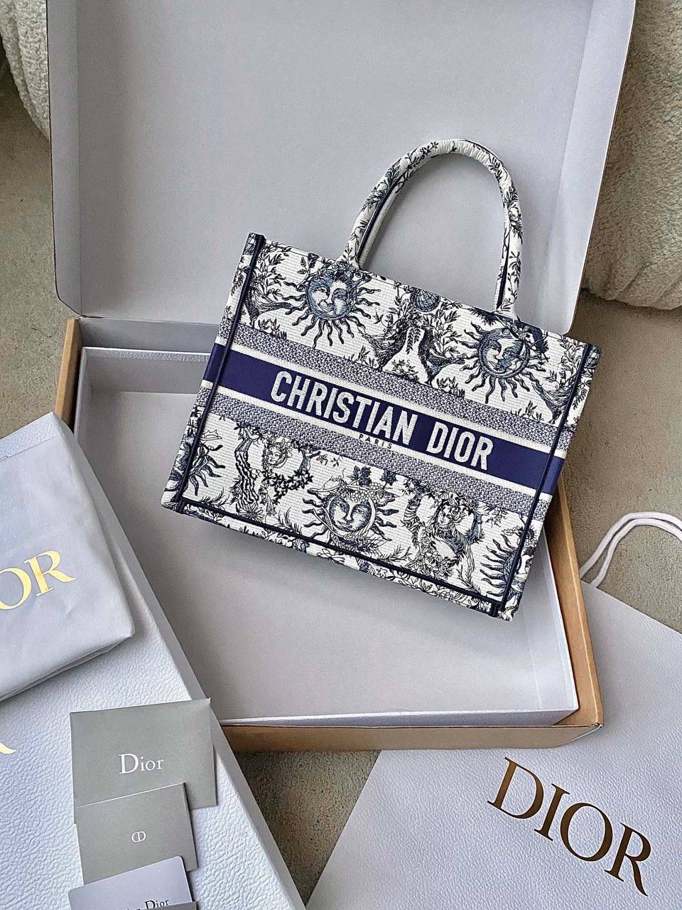 🈶蓝白中号 𝗖𝗗 𝗕𝗼𝗼𝗸 𝗧𝗼𝘁𝗲 24太阳神阳光茹伊 它有代表春天的玫瑰 夏天的麦穗，秋天的枫叶 以及冬日的枝干🍂 整个太阳也是关于守护的象征 寓意是非常美好的，浪漫且神秘 那种高定视觉，沦陷了！！ 行走在街头很是时髦🌟🌟 36×27×16cm