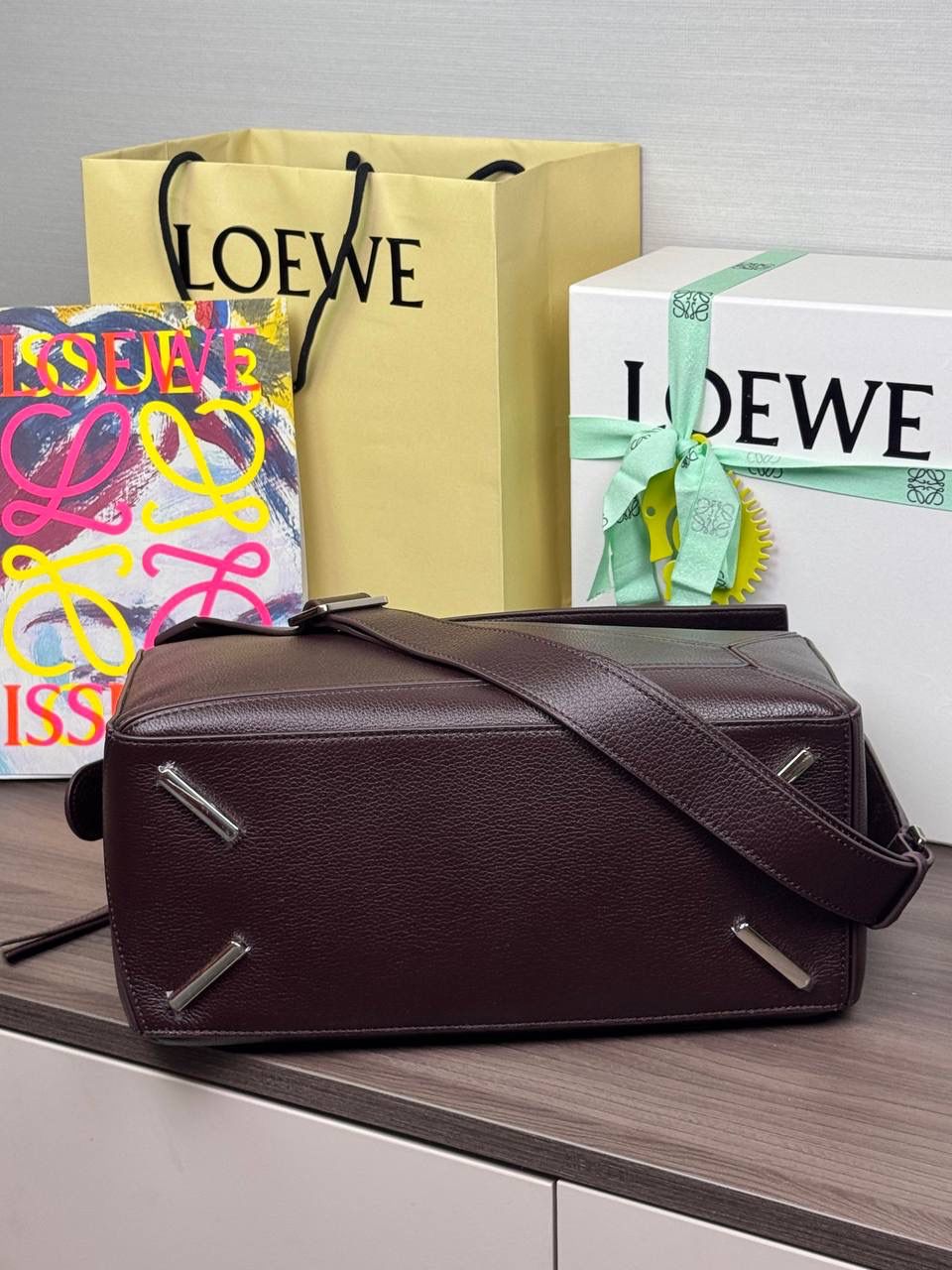 🎈【全钢】大号鹿皮𝘗𝘶𝘻𝘻𝘭𝘦* ——【👉🏻牛血色到货✅】 尺寸：𝟑𝟐.𝟓-𝟏𝟒.𝟓-𝟐𝟑.𝟓𝐜𝐦 编码：260403 【配全套包装】 ❤️经典拼图系列•不规则立体几何设计•最具辨识度的立体廓形和几何美学•顶级进口皮搭配德国沙菲线•独家定制五金•𝗬𝗞𝗞拉链拉头。 ❤️该款大号采用鹿皮革制成•绒面内里•搭配一条可拆卸可调节的皮肩带•肩背斜挎或手提多样化背法。