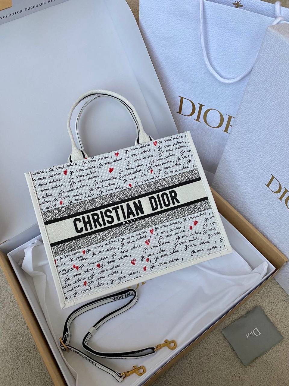🈶爱心白 𝗗𝗜𝗢𝗥 𝗯𝗼𝗼𝗸 𝘁𝗼𝘁𝗲 中号 七夕限定，更是每一天的爱意限定 情书💌款这种淡淡的色调好梦幻 从印花到纯色都散发着治愈的气息 刻印的纹理感，伸手可触 连绵不断的法语我爱你'点缀着爱心❤️ 是写满了法式浪漫的包包呀！ 请拥有，这独一份的爱意 36×16×27cm